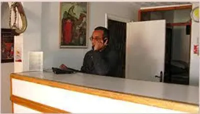 a man sitting at a counter in a room at Hotel Bab Sahara in Ouarzazate