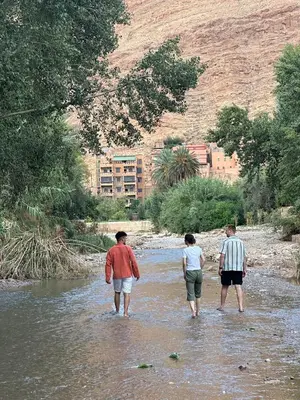 a group of three people walking in a river at Dar Relax Hostel, Gorges de Todra in Tinerhir