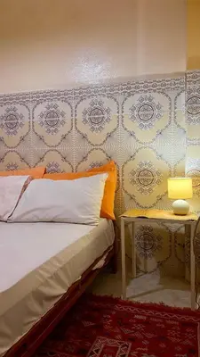 a bedroom with a bed and a side table at Dar Relax Hostel, Gorges de Todra in Tinerhir