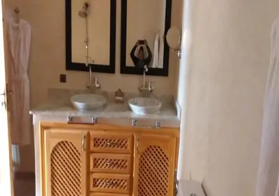 a bathroom with two sinks and two mirrors at Kasr Tin Hinane in Merzouga