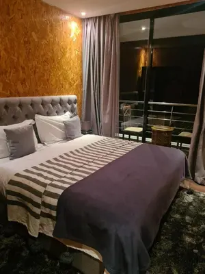 a bedroom with a large bed and a balcony at La Perle de l'Ourika in Ourika