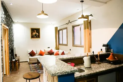 a kitchen with a sink and a living room with a couch at Issli appartment climatisé hiver et été in Azrou