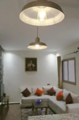 a living room with a couch and a light fixture at Issli appartment climatisé hiver et été in Azrou