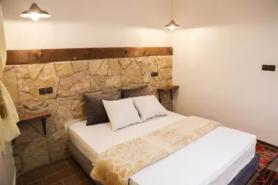a bed in a room with a stone wall at Issli appartment climatisé hiver et été in Azrou