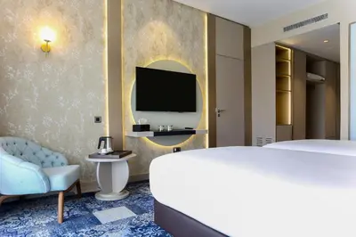 a bedroom with a bed and a tv and a chair at Oriental Palace by Agora Complex in Taza