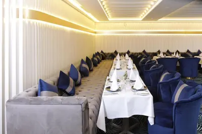 a dining room with white tables and blue chairs at Oriental Palace by Agora Complex in Taza