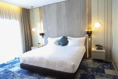 a bedroom with a large white bed and a window at Oriental Palace by Agora Complex in Taza