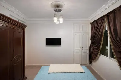 a room with a bed and a tv and a window at Residence Bouanane B in Fès