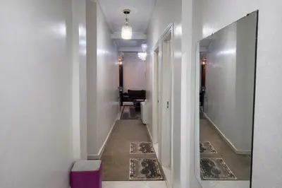 a hallway with a mirror and a room with a table at Residence Bouanane B in Fès