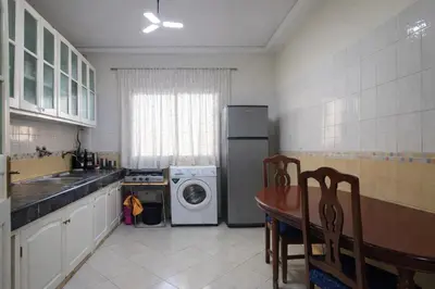 a kitchen with a table and a washer and dryer at Residence Bouanane B in Fès