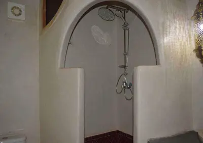 a shower in the corner of a bathroom at Riad Tin Hinane in Merzouga
