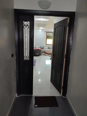 a hallway with a black door and a living room at STOPOVER 1 MIDELT in Midelt