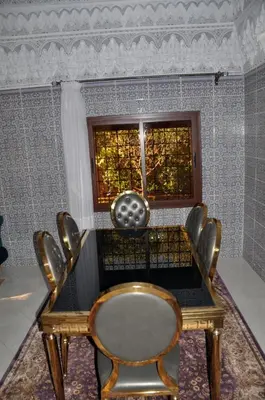 a dining room table with a chair and a window at Jolie villa moderne avec piscine privée. in Marrakech