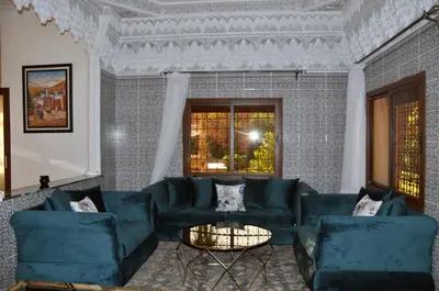 a living room with blue couches and a table at Jolie villa moderne avec piscine privée. in Marrakech