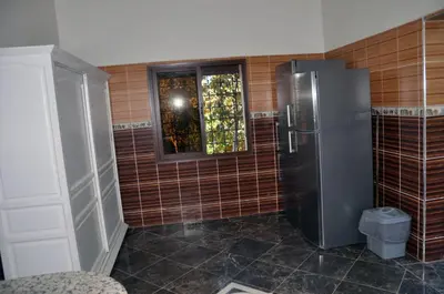 a kitchen with a refrigerator and a window at Jolie villa moderne avec piscine privée. in Marrakech