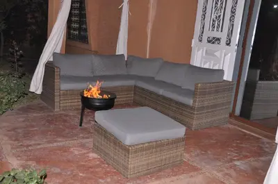 a couch sitting on a patio with a fire pit at Jolie villa moderne avec piscine privée. in Marrakech