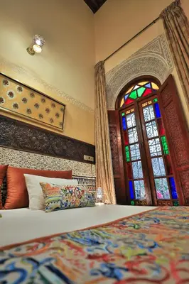 a bedroom with a bed and a stained glass window at Riad Moulaydriss et Giacomo in Fès