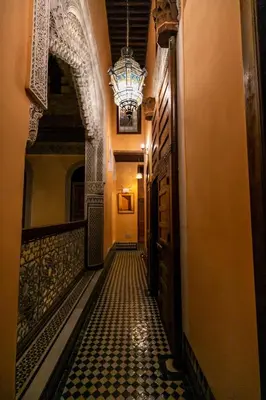 a corridor of a building with a chandelier at Riad Moulaydriss et Giacomo in Fès