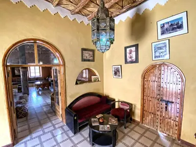 a living room with a couch and a chandelier at Guest House Defat Kasbah in Aït Ben Haddou