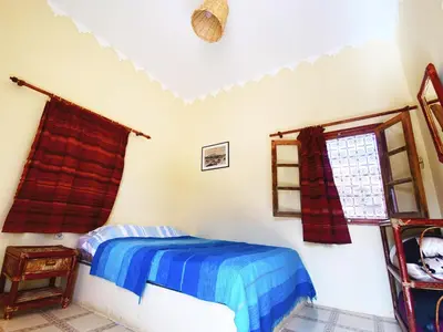 a bedroom with a bed and a window at Guest House Defat Kasbah in Aït Ben Haddou