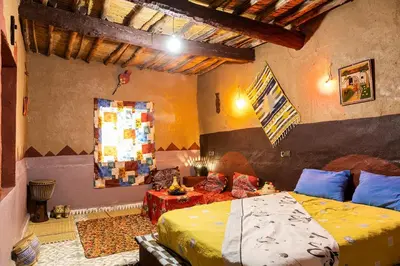 a bedroom with a bed and a couch in a room at Dar Jamila in Achbarou