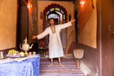 a man standing in front of a table with his arms out at Dar Jamila in Achbarou