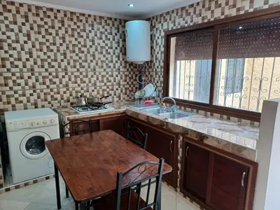 a kitchen with a table and a sink and a stove at The Orchard Comfy & Cozy Apartment 2 in Ifrane