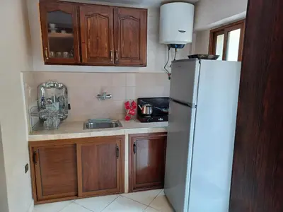 a kitchen with a white refrigerator and wooden cabinets at The Orchard Comfy & Cozy Apartment 2 in Ifrane