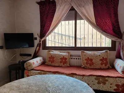 a living room with a couch with pillows and a window at The Orchard Comfy & Cozy Apartment 2 in Ifrane