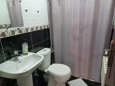 a bathroom with a white toilet and a sink at The Orchard Comfy & Cozy Apartment 2 in Ifrane