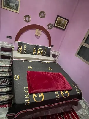 a bedroom with a bed with a black and red blanket at Appartement moha merzouga in Merzouga