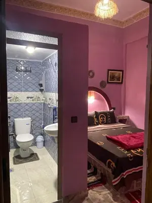 a purple bedroom with a bed and a toilet at Appartement moha merzouga in Merzouga