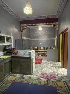 a kitchen with a counter and a tile floor at Appartement moha merzouga in Merzouga