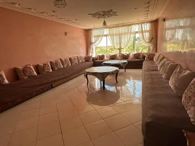 a large living room with a long couch and a table at Stunning 3-Bed Villa in Fes near fes sais airport in Fès