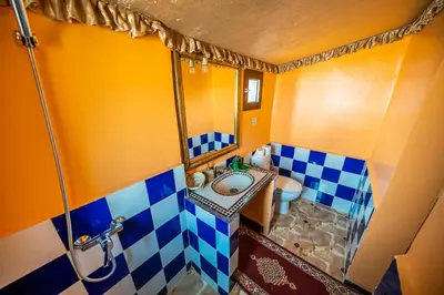 a small bathroom with a sink and a shower at Aladdin Desert Lodge - Mhamid Sahara Camp in El Gouera