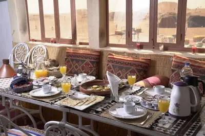 a table with food and drinks on top of it at Aladdin Desert Lodge - Mhamid Sahara Camp in El Gouera