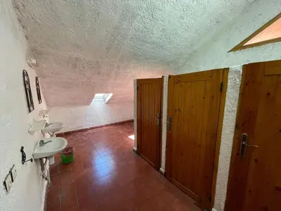 a bathroom with a sink and a toilet and a door at Gîte Camping Amazigh in Azrou
