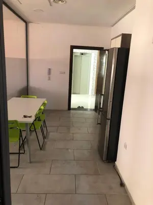 a dining room with a table and a refrigerator at Chez ZAKARIA de Lyon in Meknès