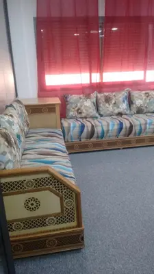 a room with two beds and a couch at Chez ZAKARIA de Lyon in Meknès