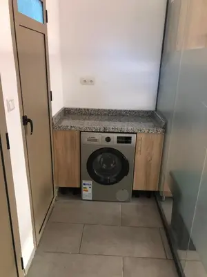 a small laundry room with a washer and dryer at Chez ZAKARIA de Lyon in Meknès