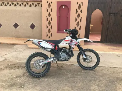 a dirt bike parked in front of a house at Riad Moha in Merzouga