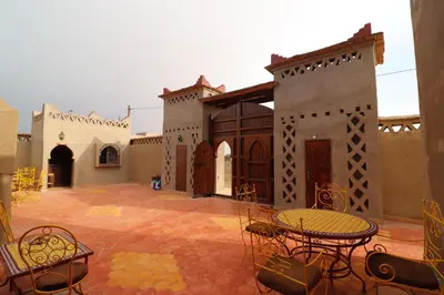 a patio with tables and chairs in a courtyard at Riad Moha in Merzouga