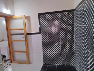 a bathroom with a shower with black and white tile at Hotel et Restaurant Riad Amodou in Tinerhir