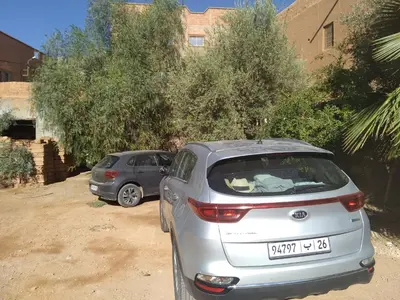 two cars parked next to each other on a dirt road at Hotel et Restaurant Riad Amodou in Tinerhir