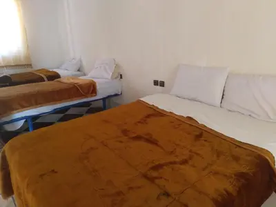 a room with two beds and a couch at Hotel et Restaurant Riad Amodou in Tinerhir