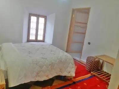 a bedroom with a white bed and a window at Hotel et Restaurant Riad Amodou in Tinerhir