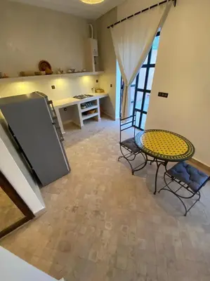 a kitchen with a table and chairs in a room at Dar Mamoun in Marrakech