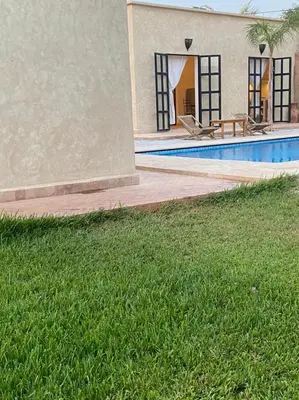a house with a swimming pool next to a building at Dar Mamoun in Marrakech