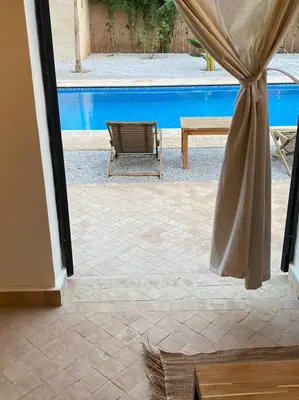 a view of a pool from a window with a curtain at Dar Mamoun in Marrakech