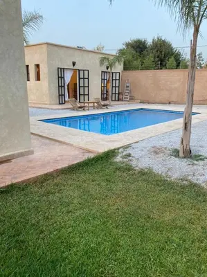 a swimming pool in front of a house at Dar Mamoun in Marrakech